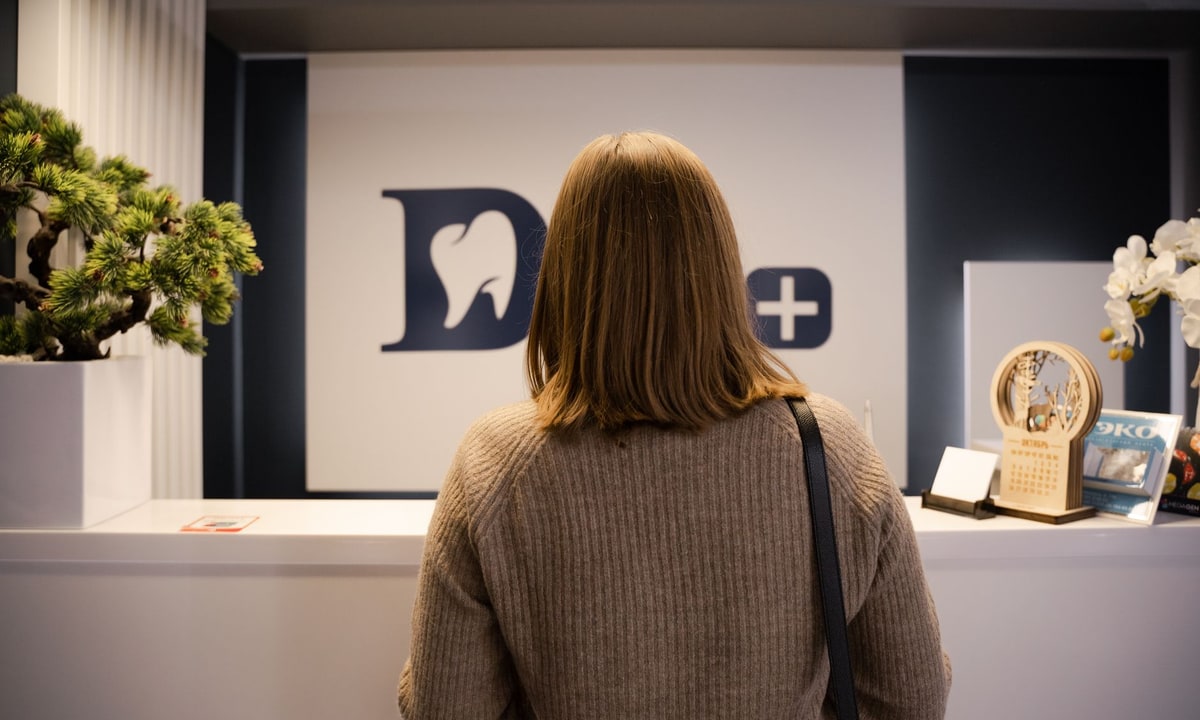 Dental office reception desk with a phone and scheduling paperwork