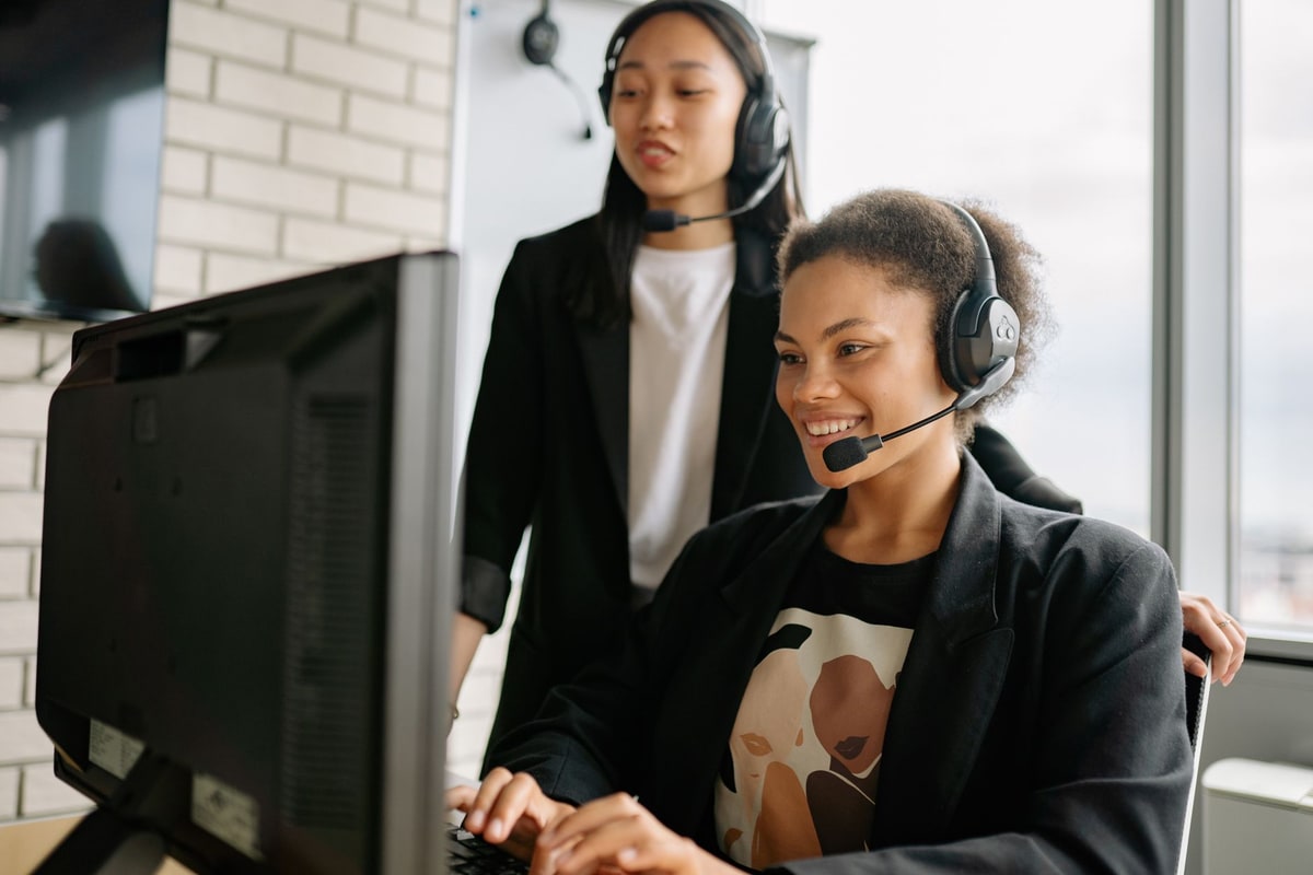 Customer support agent with headset answering chats on a computer