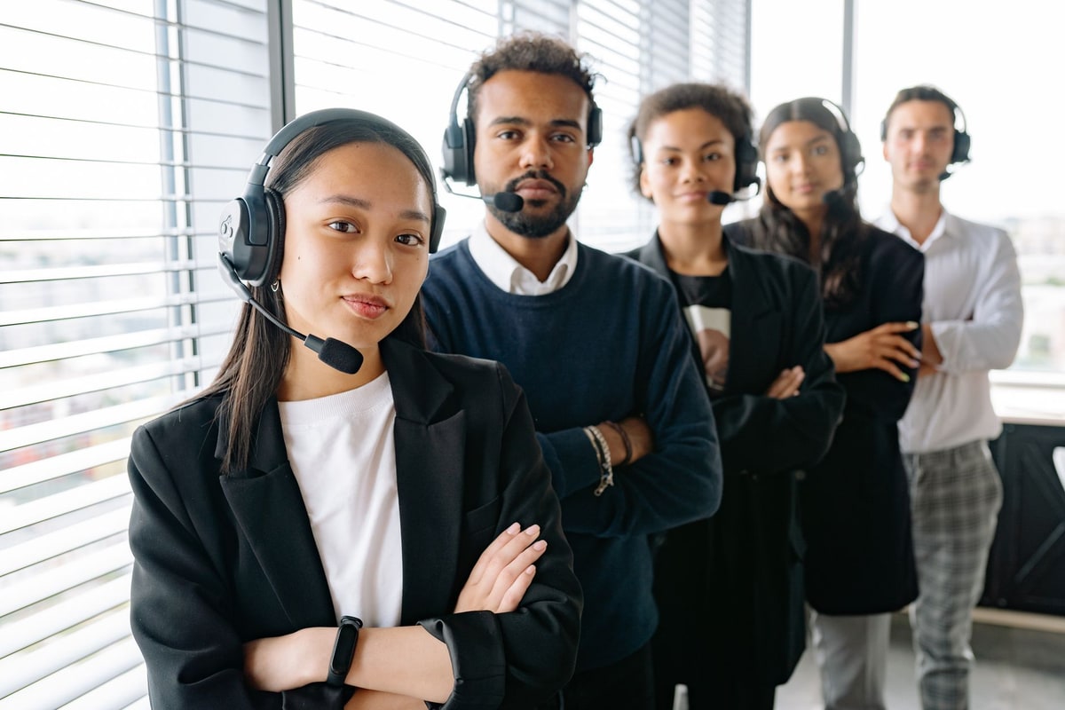 Call center team with headsets helping customers in an office