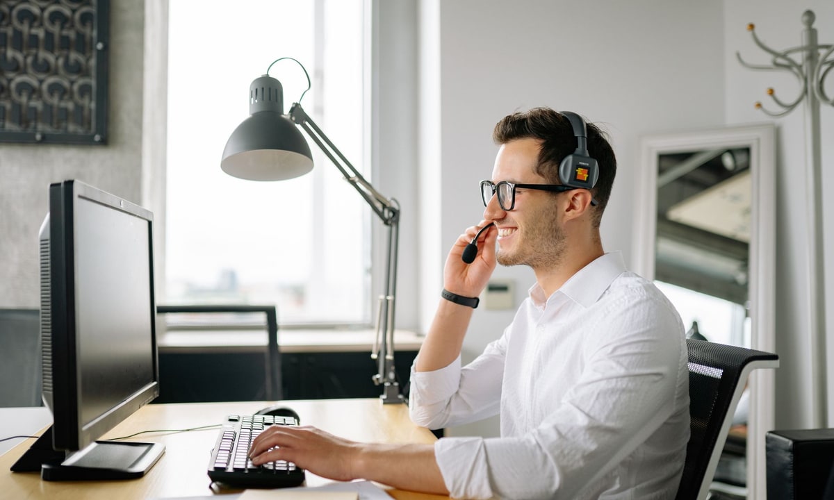 Receptionist wearing a headset answering a call at an office desk