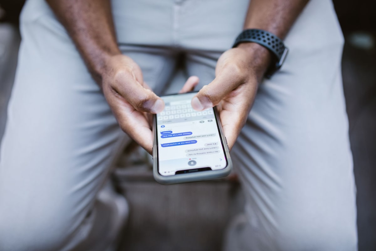 Close-up of a hand texting a follow-up message on a smartphone