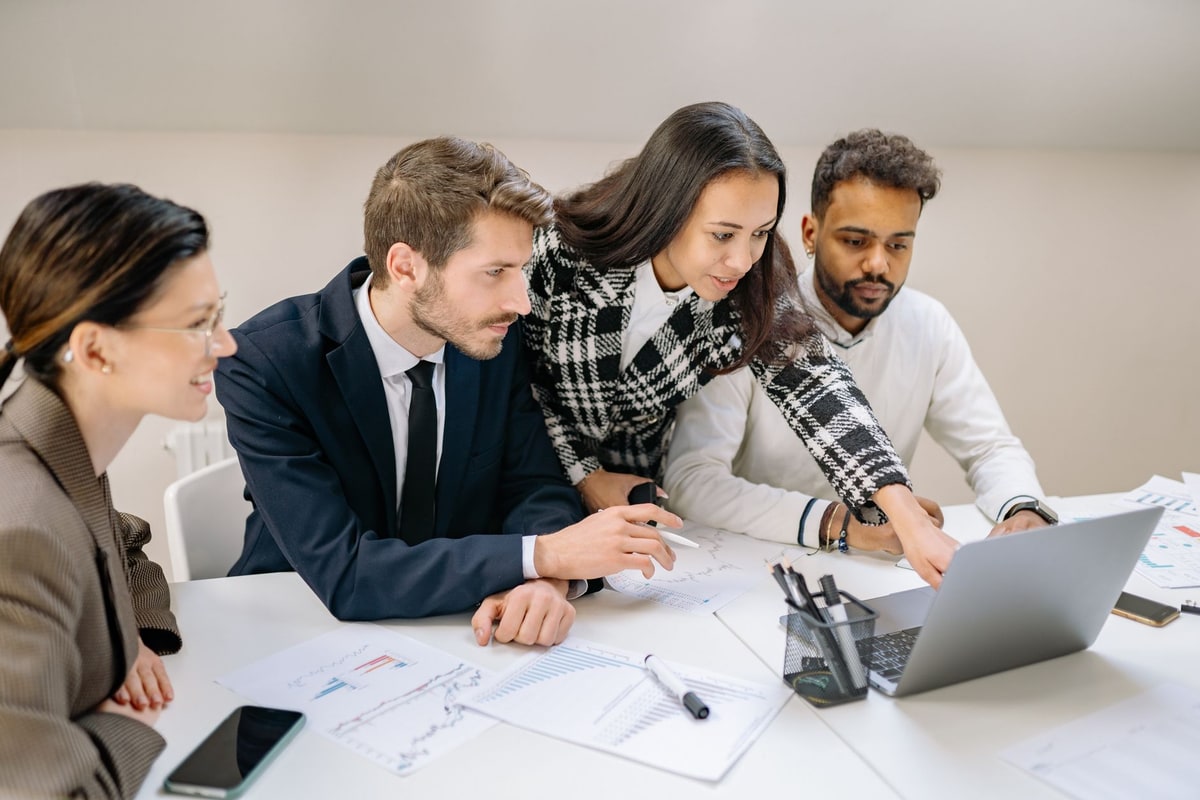 Sales team reviewing lead follow-up performance on a laptop during a meeting