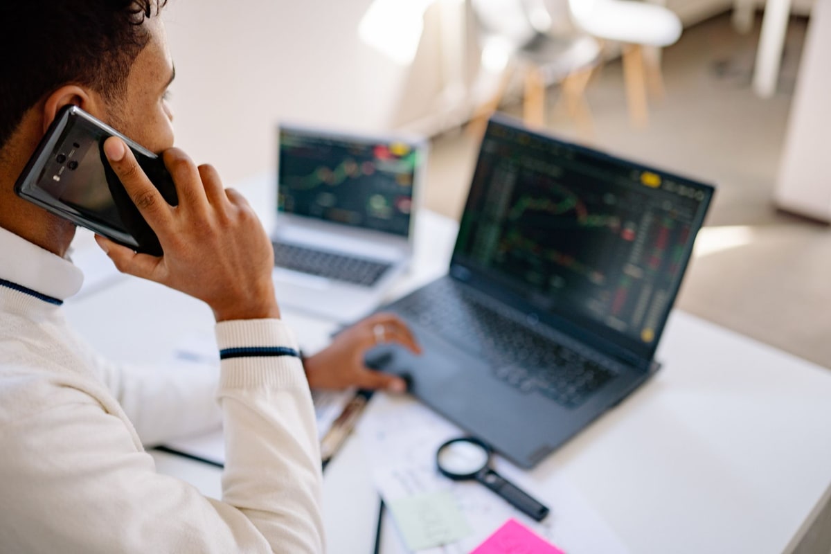 Salesperson working with a laptop and phone at a desk