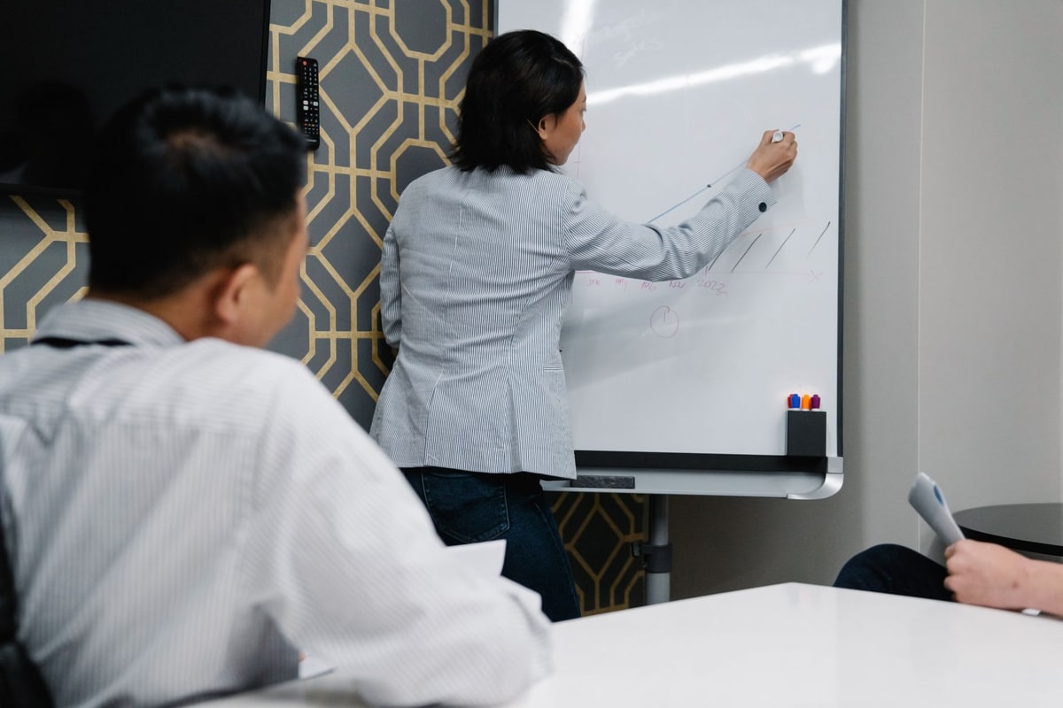 Agency operations team mapping feedback states and owner handoffs on a whiteboard