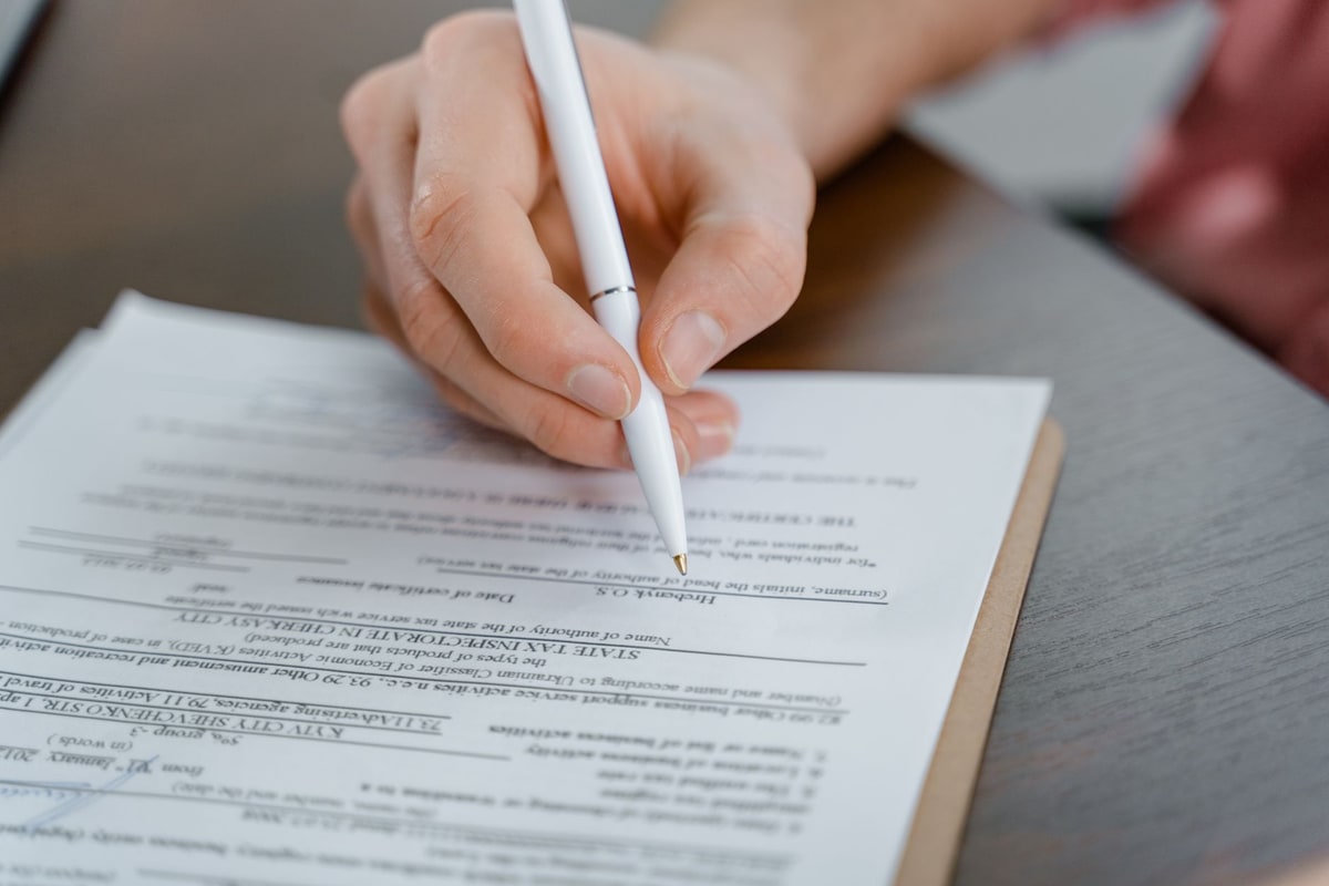 Hand signing a legal document with a pen