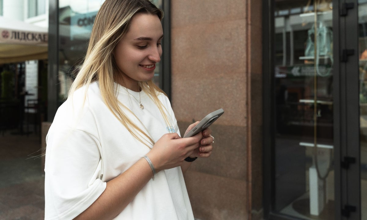 Business owner comparing a text message with an email for follow-up