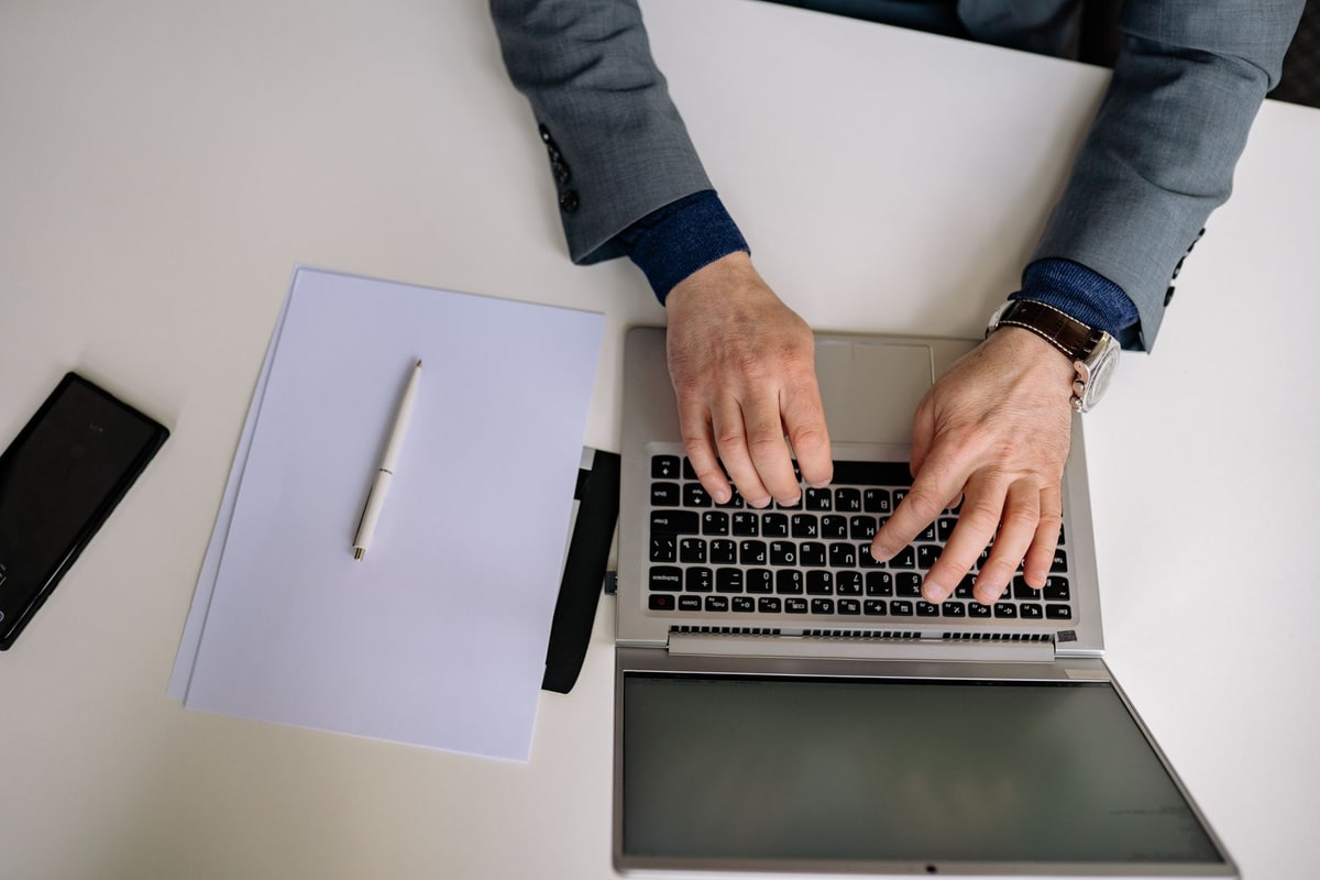 Manager checking customer records and ownership on a laptop