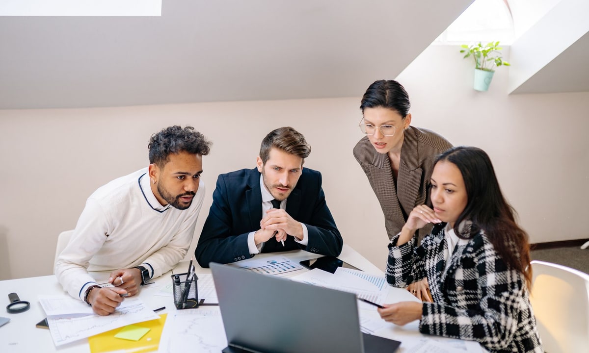 Office team checking records on a laptop during an integration review
