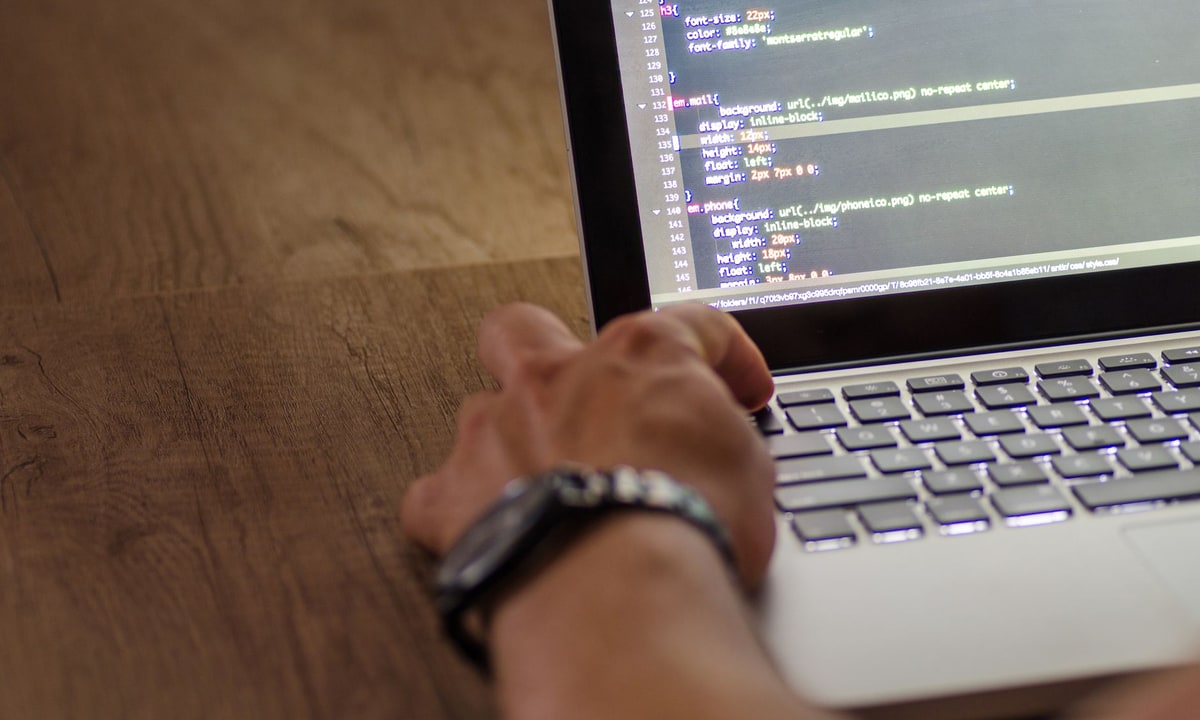 Operations specialist reviewing webhook delivery logs on a laptop