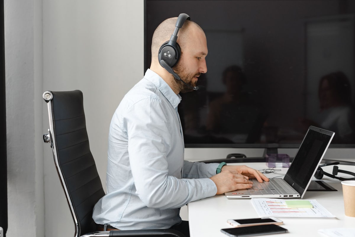 Salesperson reviewing a CRM pipeline on a laptop in a small business office