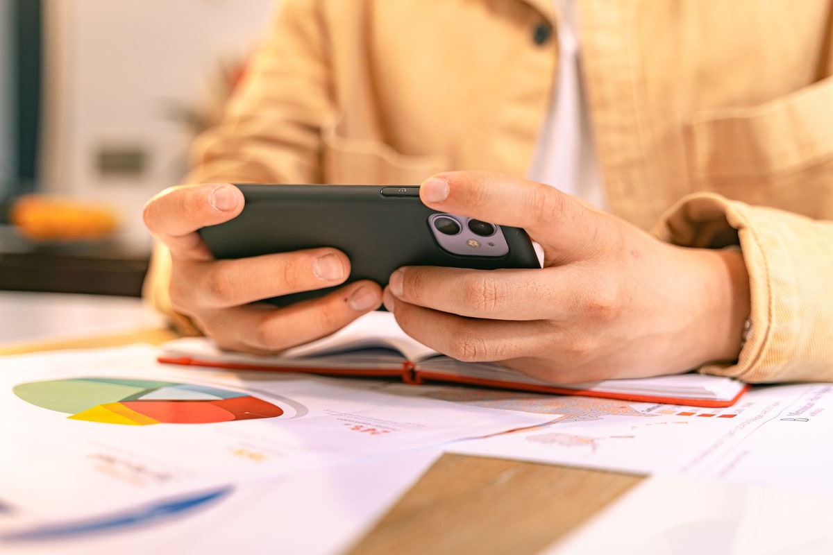 Owner reviewing follow-up messages on a phone at a desk
