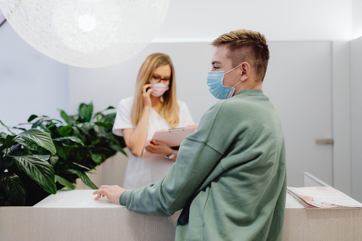 Clinic receptionist using a phone and scheduling system