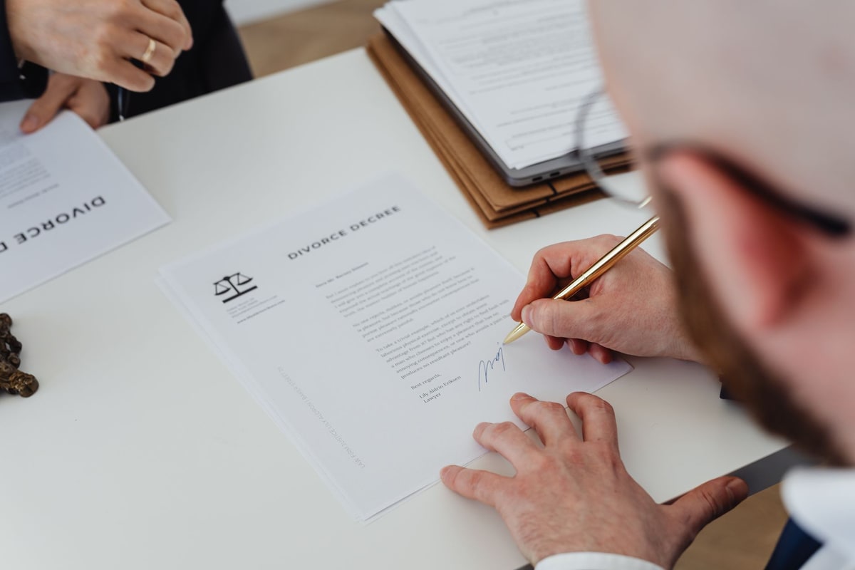 Business buyer signing a sales agreement at a table