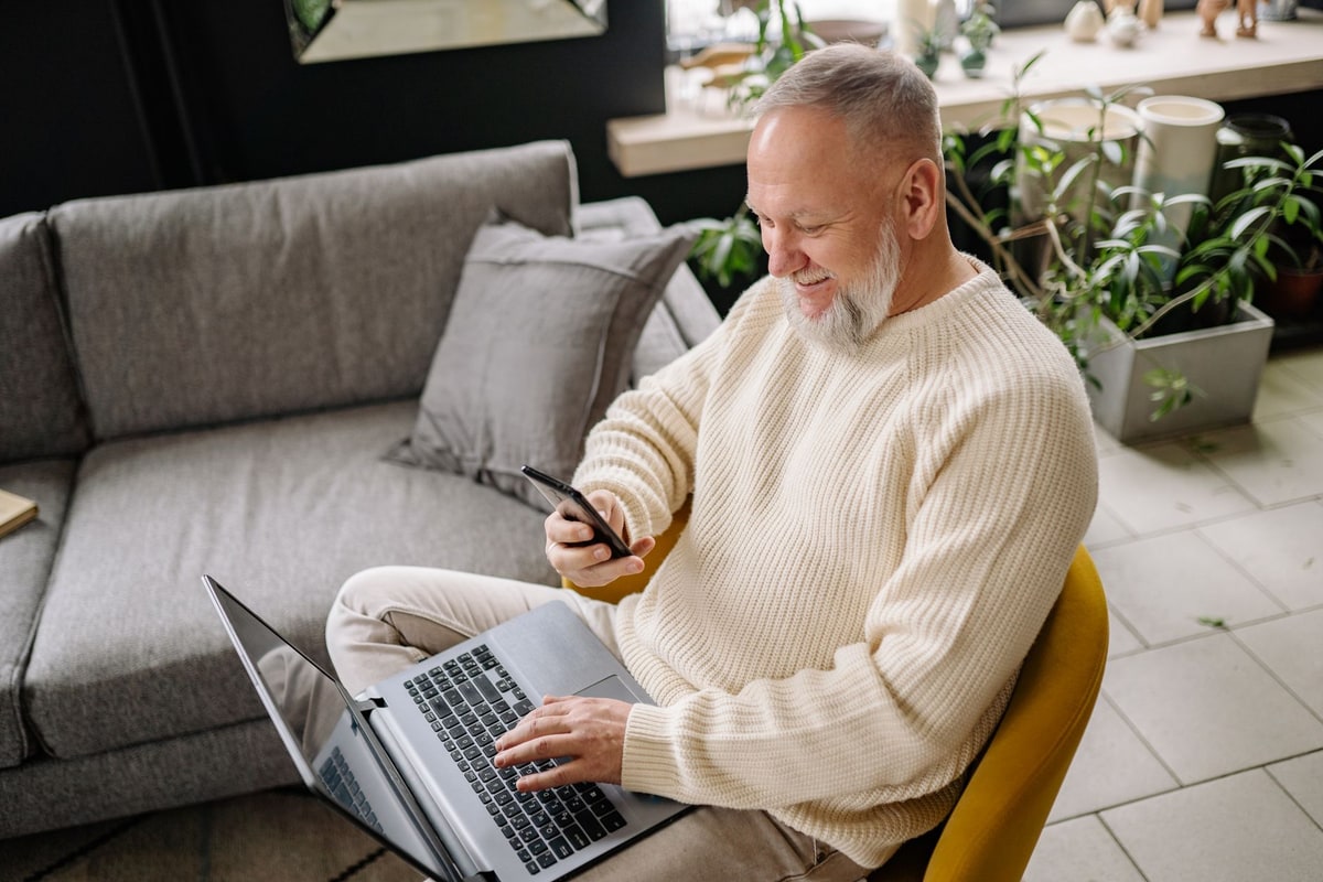 Real estate investor reviewing a property lead and follow-up status on a phone and laptop