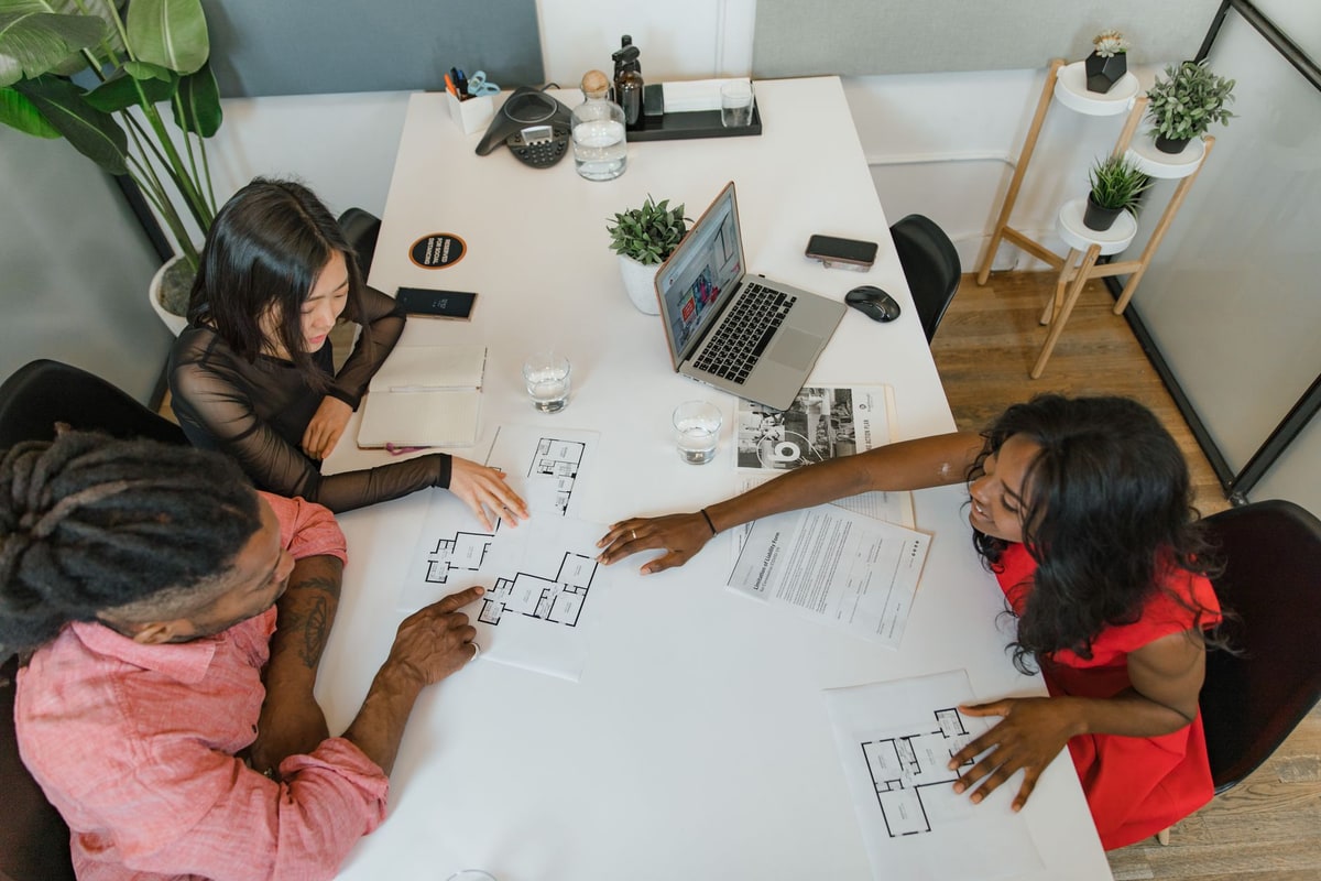 Real estate acquisitions team reviewing a CRM implementation checklist in a meeting