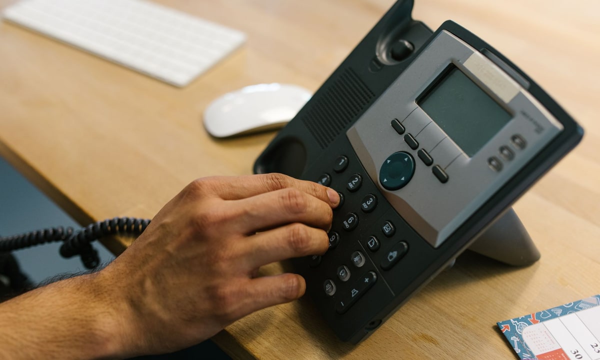 Service business desk with a phone showing an unanswered lead alert