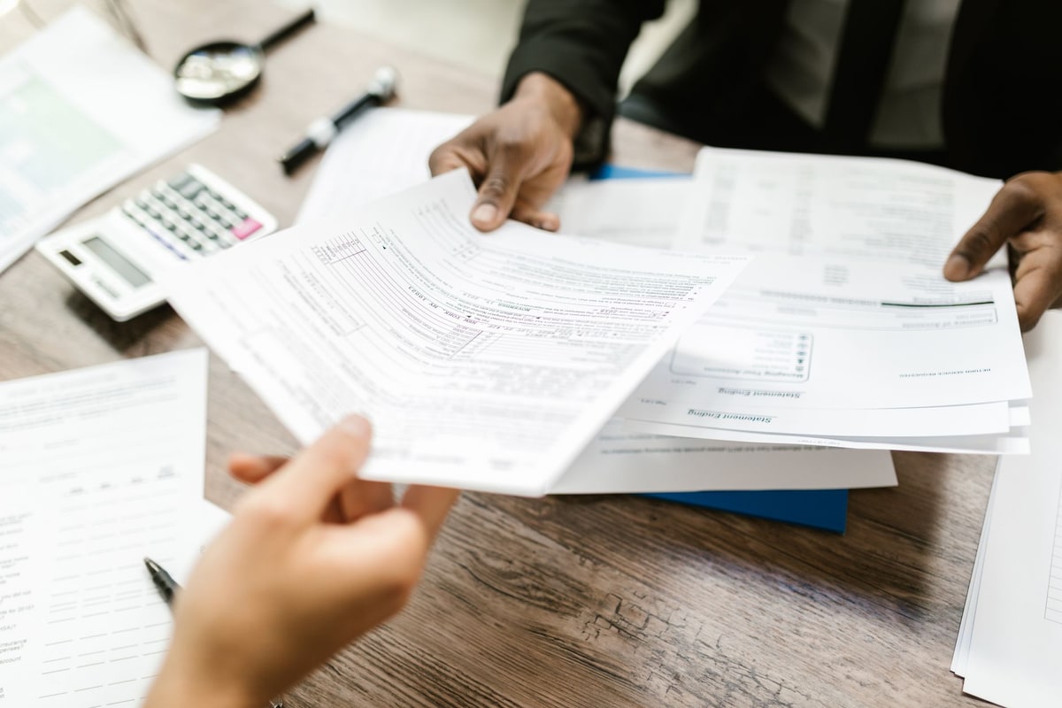 Invoice moving through review and approval steps on a desk