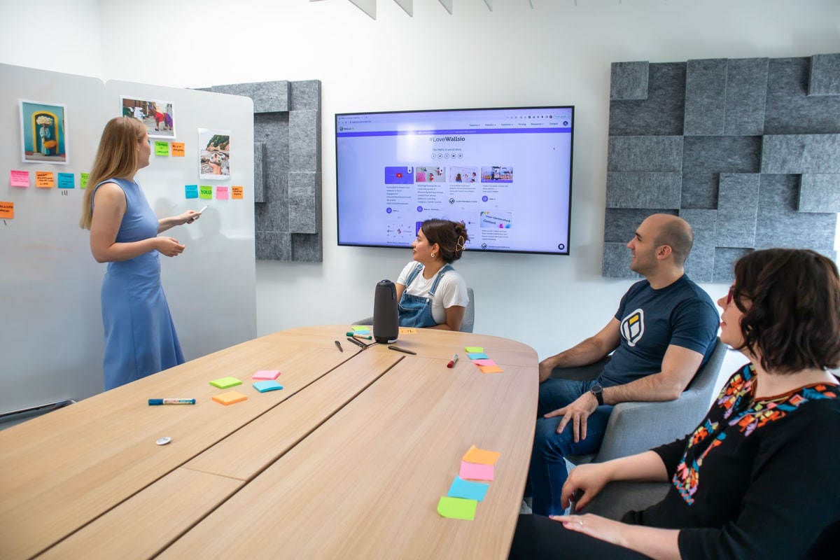Operations team comparing workflow diagrams on a large screen