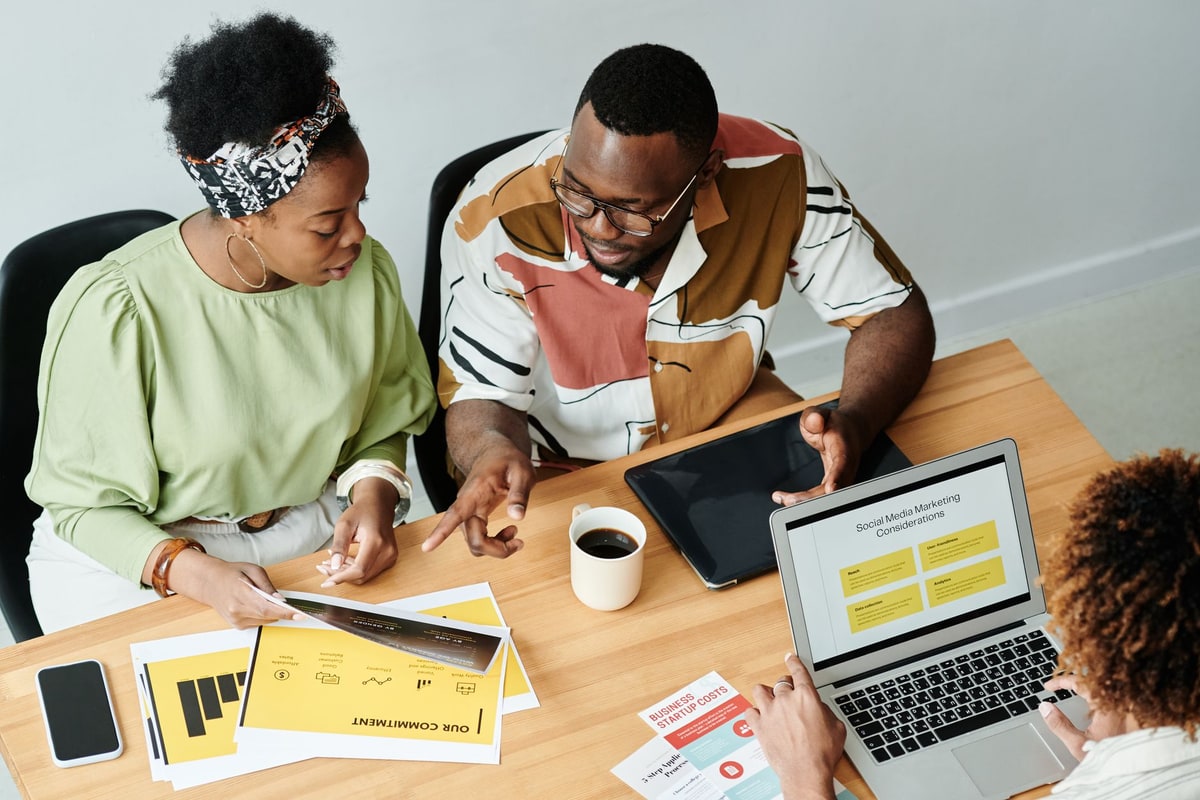 Marketing team discussing lead routing beside a laptop