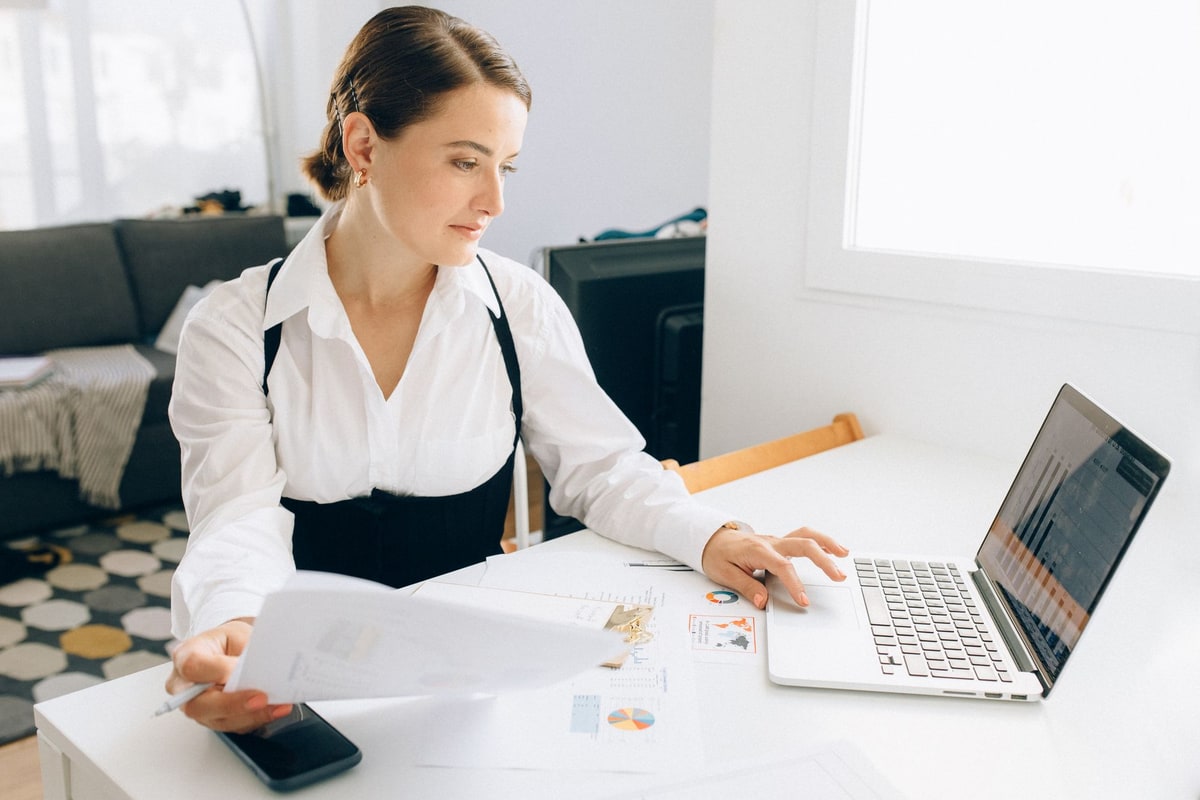 Analyst reviewing business reports on a laptop