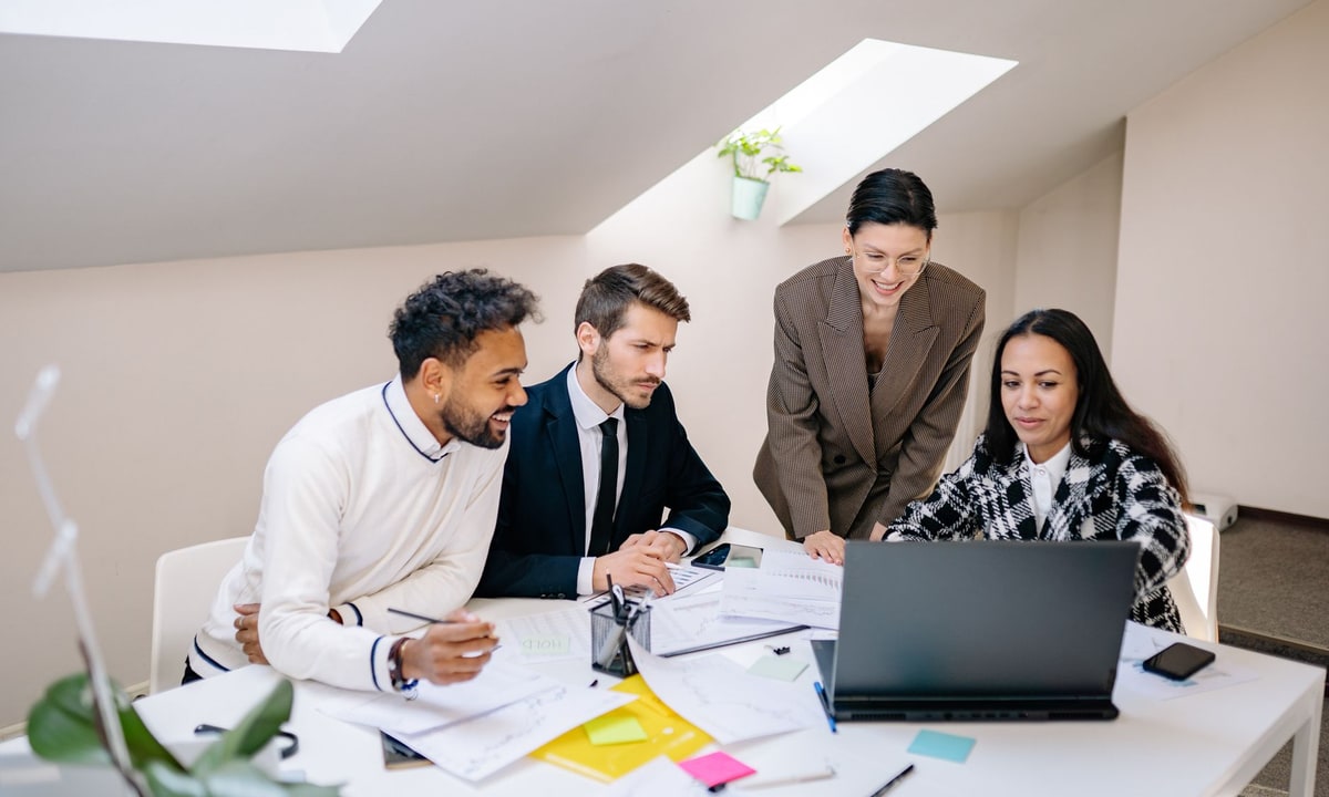 Agency team comparing automation options around a laptop