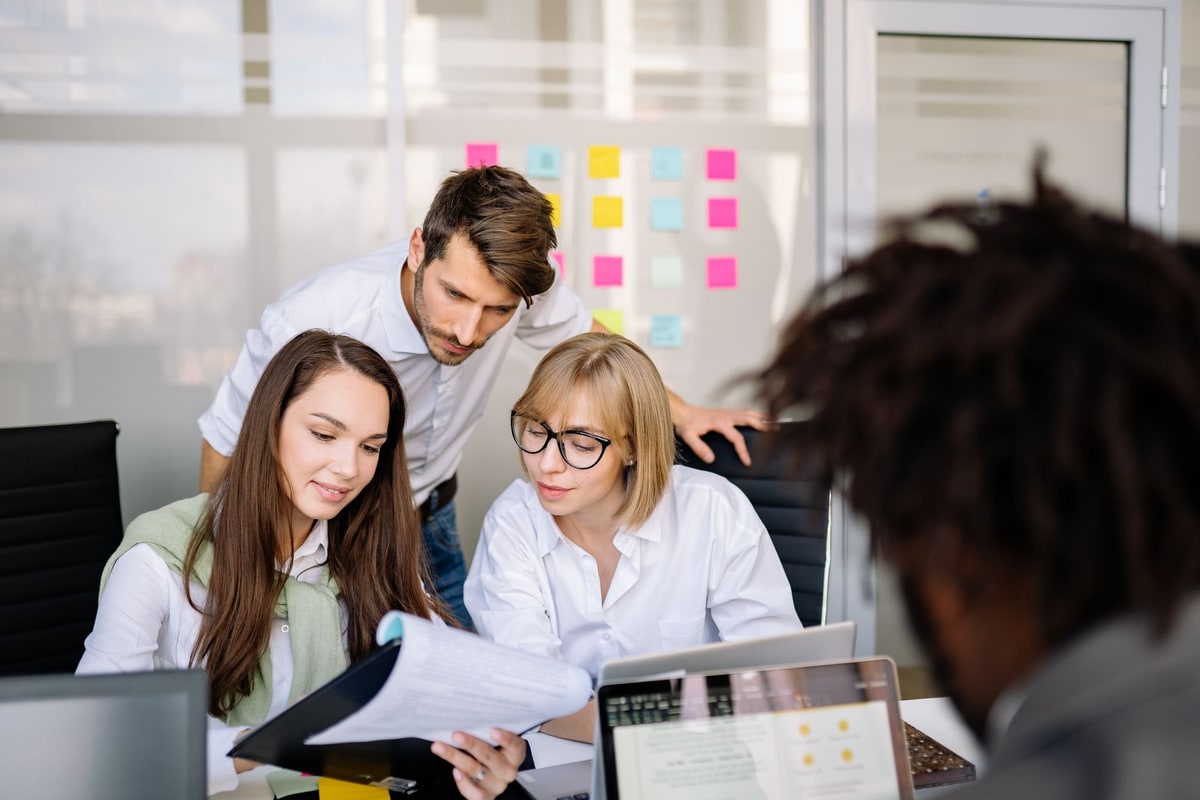 Sales team reviewing workflow options on screens in an office